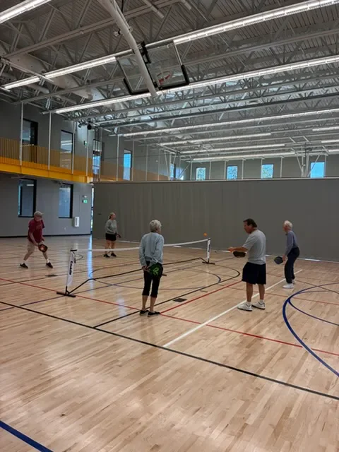 Coach Mark Boehm running drills with a small group of adult players in a gym