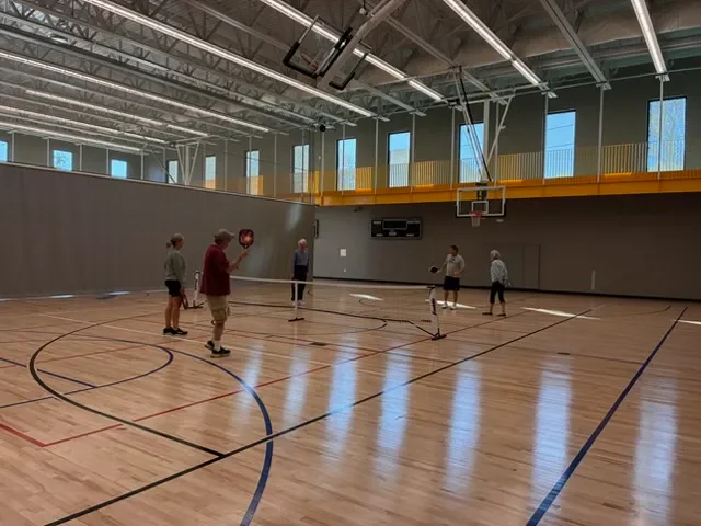 Coach Mark Boehm leading a group session for adult players in a gym