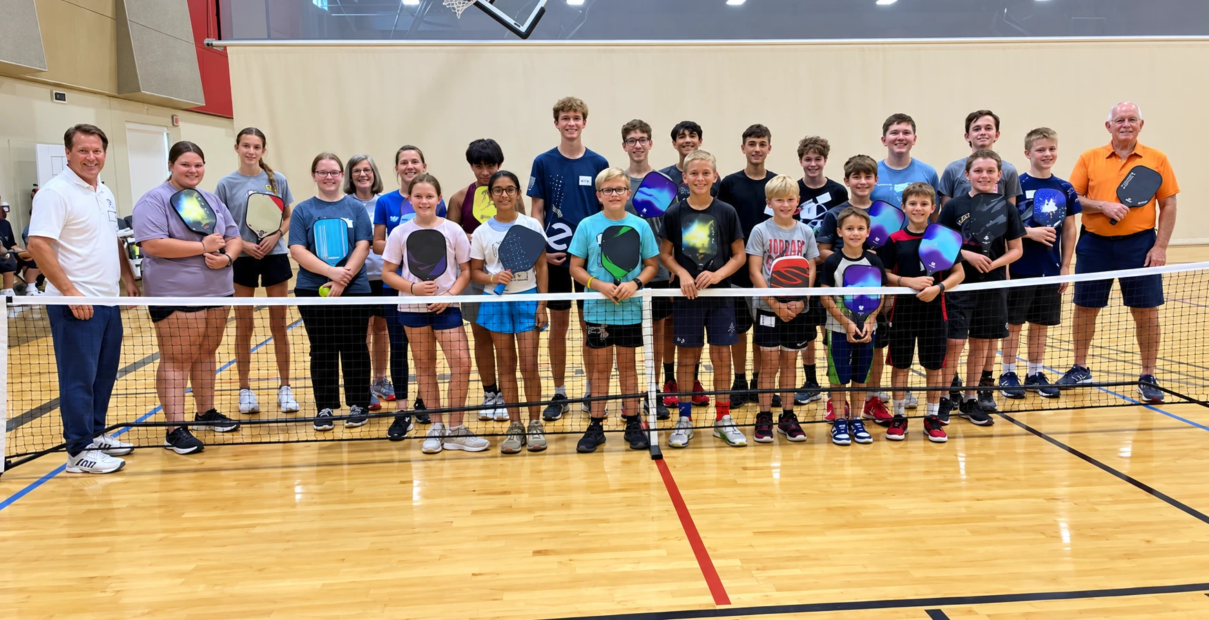Coach Mark Boehm with a large group of youth players and their paddles
